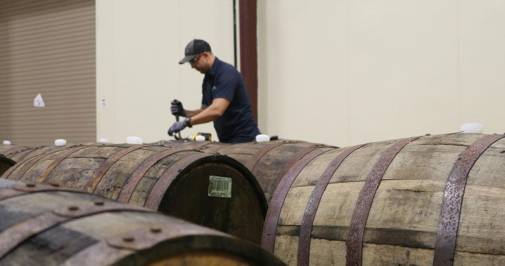Fábrica de vermouth con barricas de envejecimiento y equipo de producción.